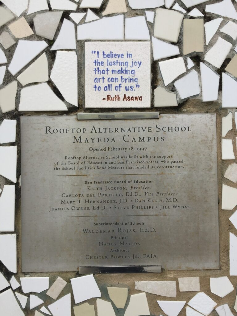 A Ruth Asawa quote, “I believe in the lasting joy that making art can bring to all of us,” is among the thousands of mosaic tiles that encircle the Mayeda Campus Dedication plaque.